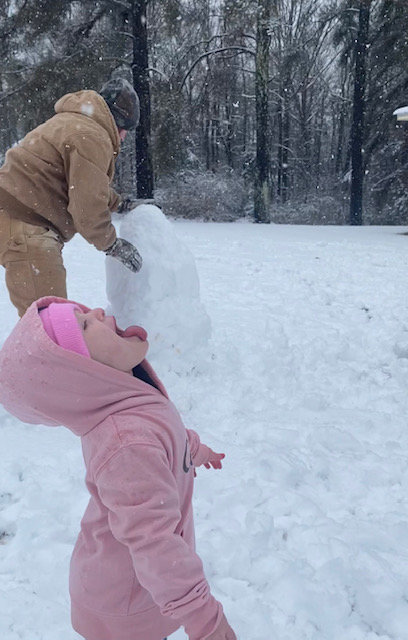 Evie Claire Jackson, 2, from the North Bend community, tries to catch a snowflake.